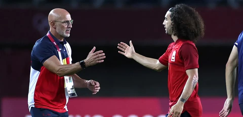 Coach and player exchanging a handshake on field