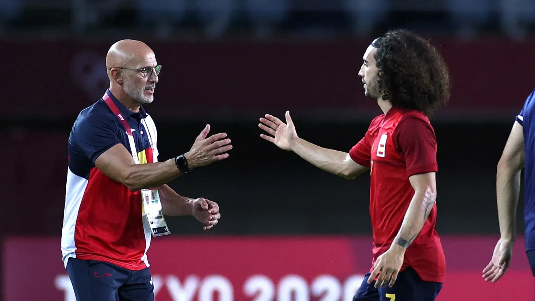 Coach and player exchanging a handshake on field