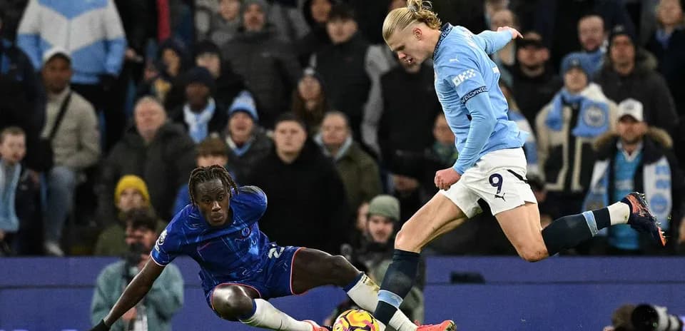 Chelsea player tackling Manchester City forward