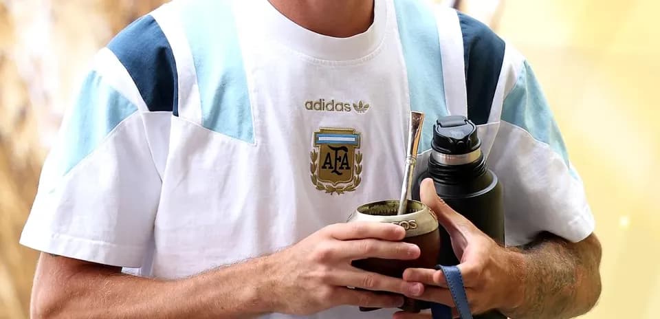 Player holding mate cup and water bottle