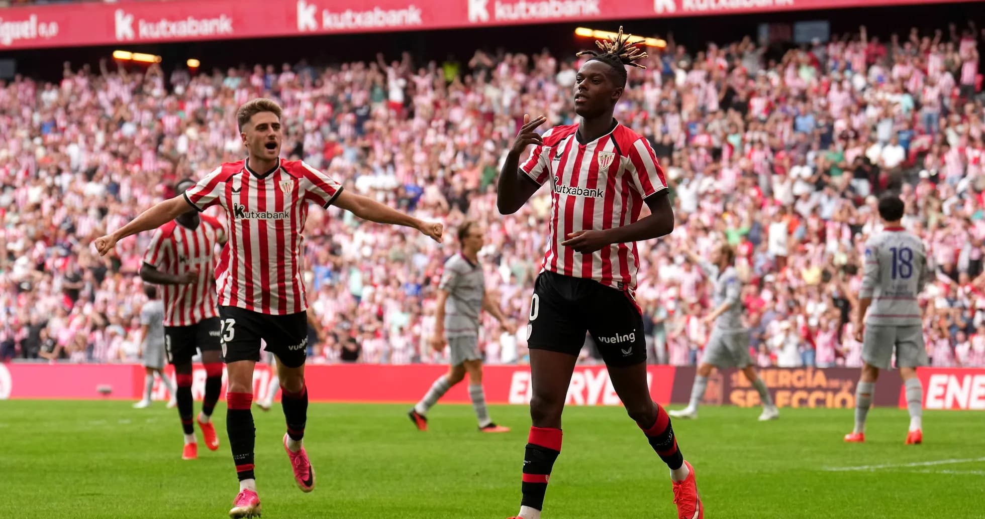 Player celebrating a goal with teammates in stadium