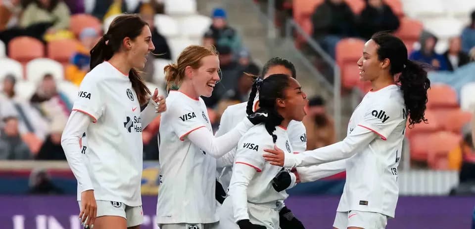 Players celebrating a goal during NWSL match