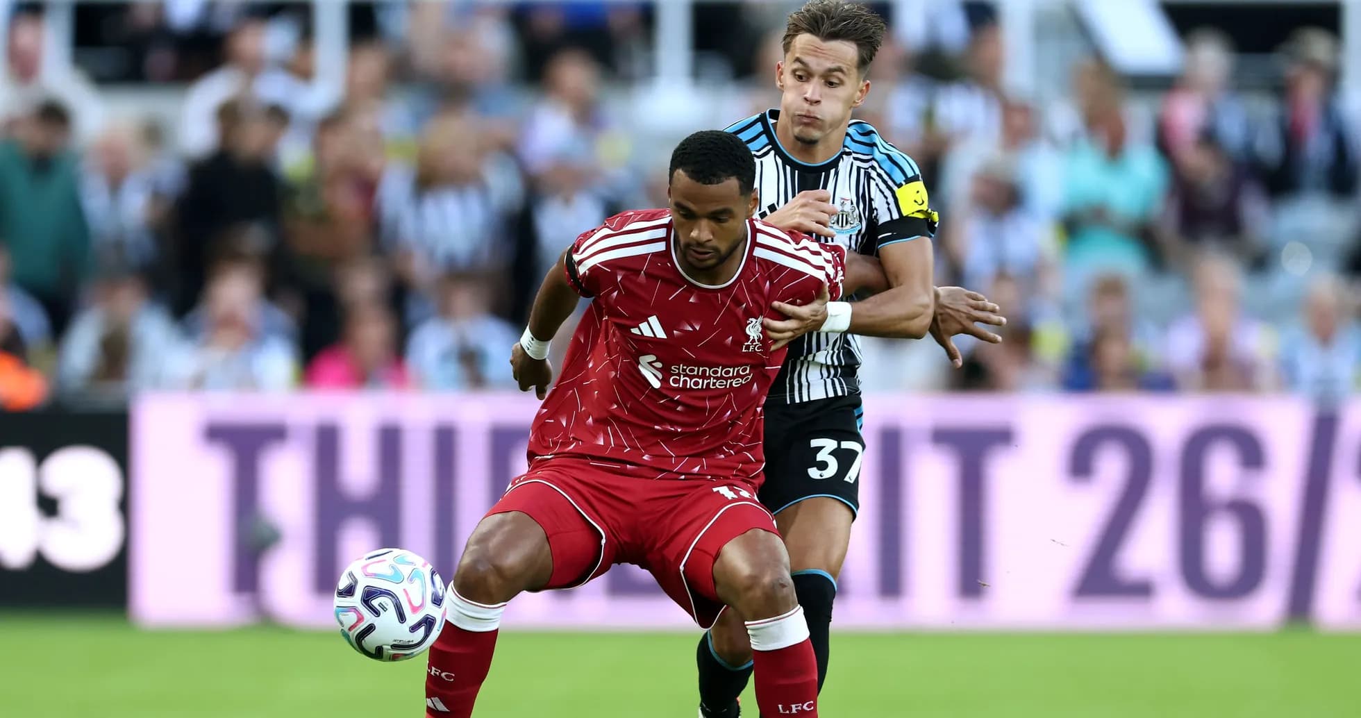 Liverpool player challenged by Newcastle opponent during match