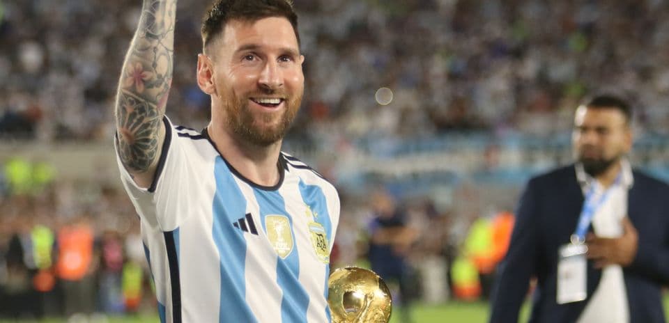 Player celebrating with trophy in stadium