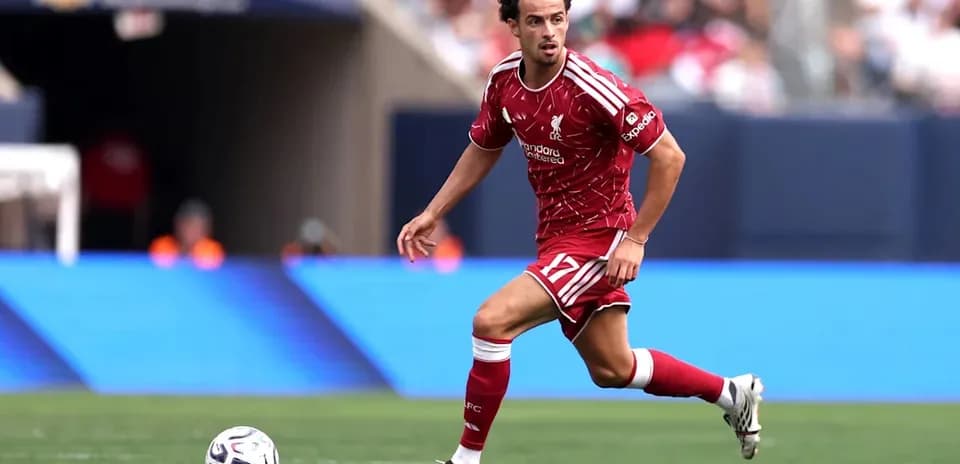 Liverpool player dribbling ball on field