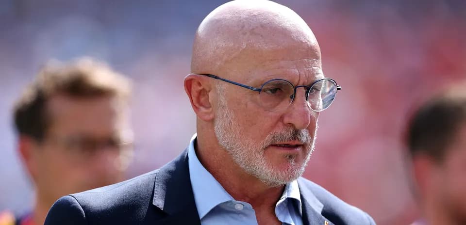 Man in suit with glasses on sports field