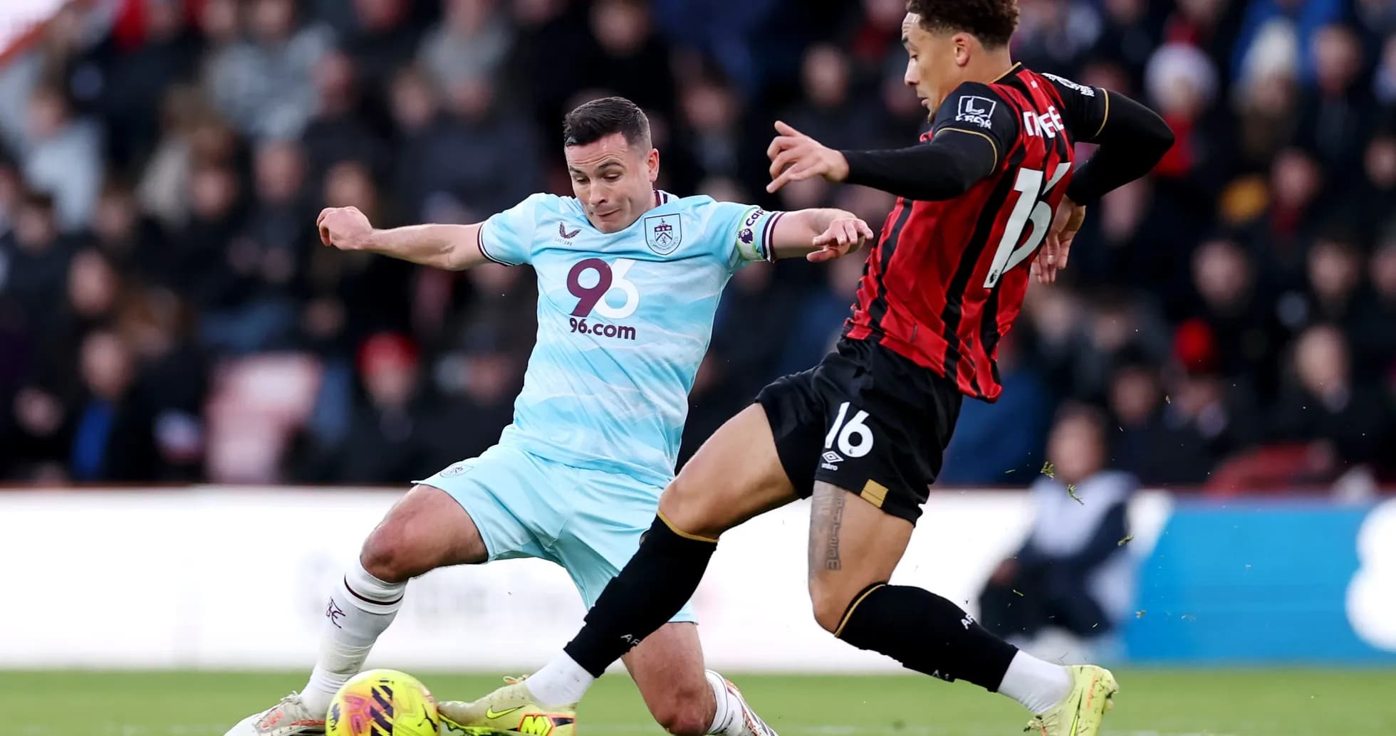 Burnley player tackling Bournemouth opponent during match