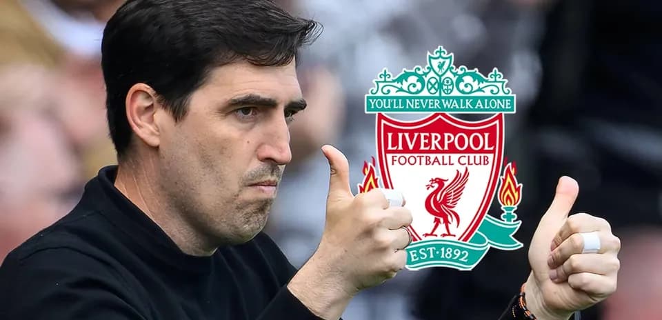 Coach giving thumbs up with Liverpool logo in background