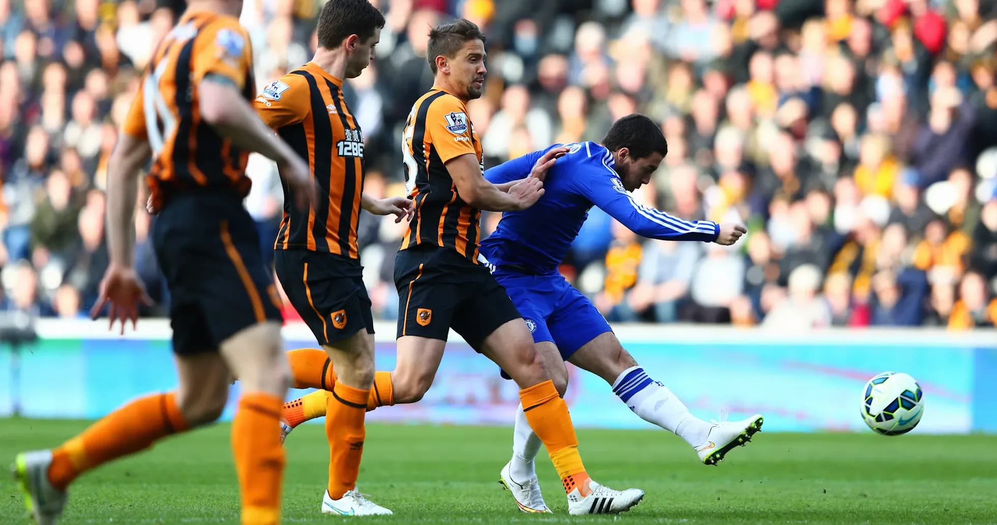 Chelsea player shooting against Hull City defenders