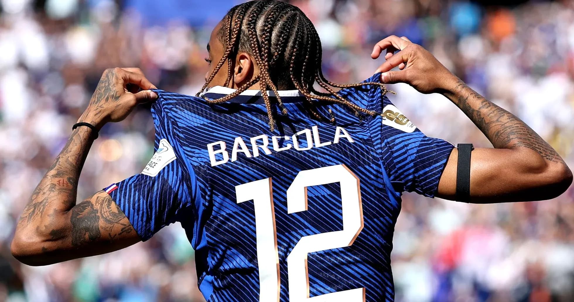 Player displaying jersey with name Barcola and number 12