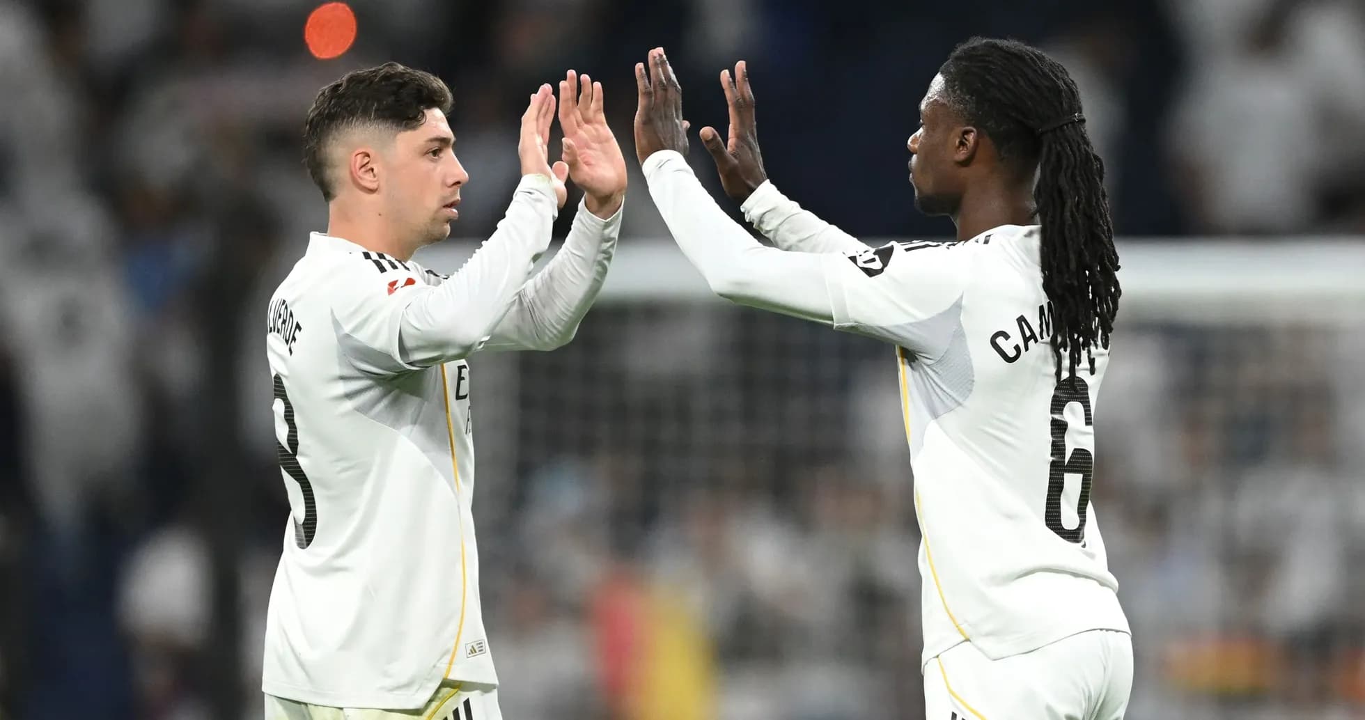Two players celebrating with high fives on field