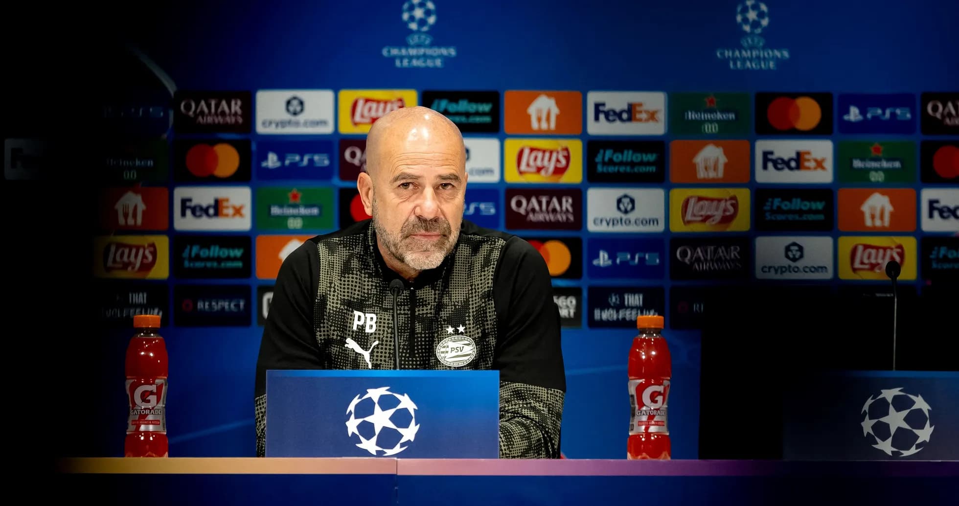 Manager at press conference with Champions League backdrop