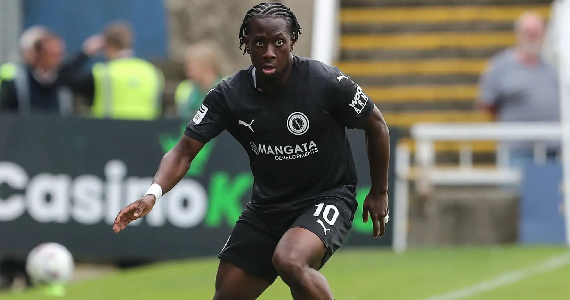 Player in black kit dribbling on the field