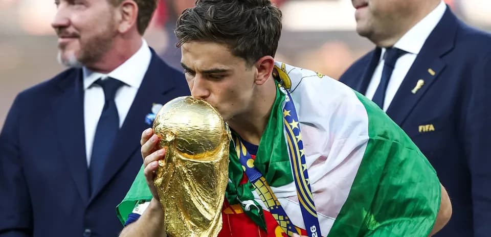 Player kissing World Cup trophy while celebrating