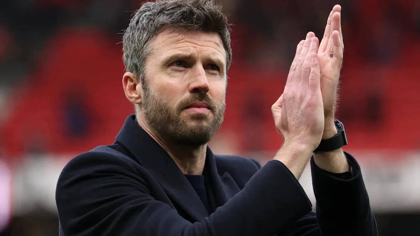 Man applauding in a stadium with red background