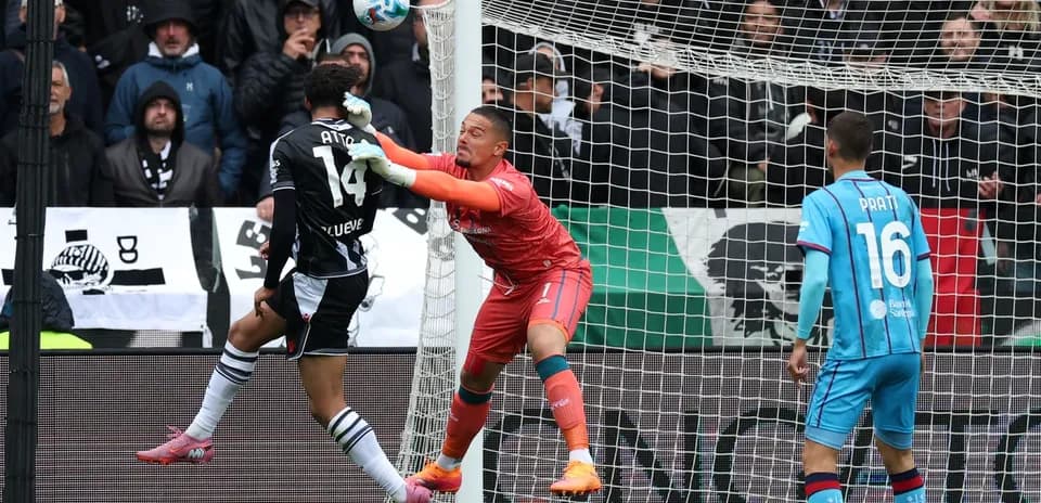 Goalkeeper attempting to save a header during match