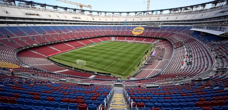 View of empty stadium with green pitch and stands
