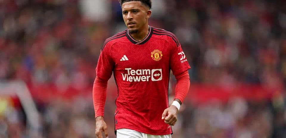 Player in Manchester United jersey walking on pitch