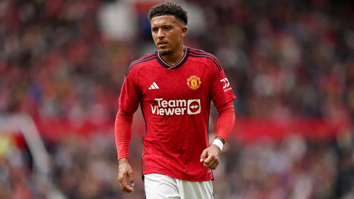Player in Manchester United jersey walking on pitch
