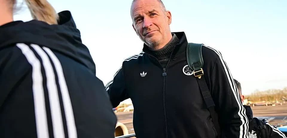 Coach wearing black tracksuit at airport