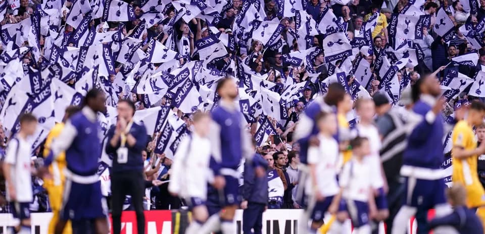 Fans waving Spurs flags during match celebration