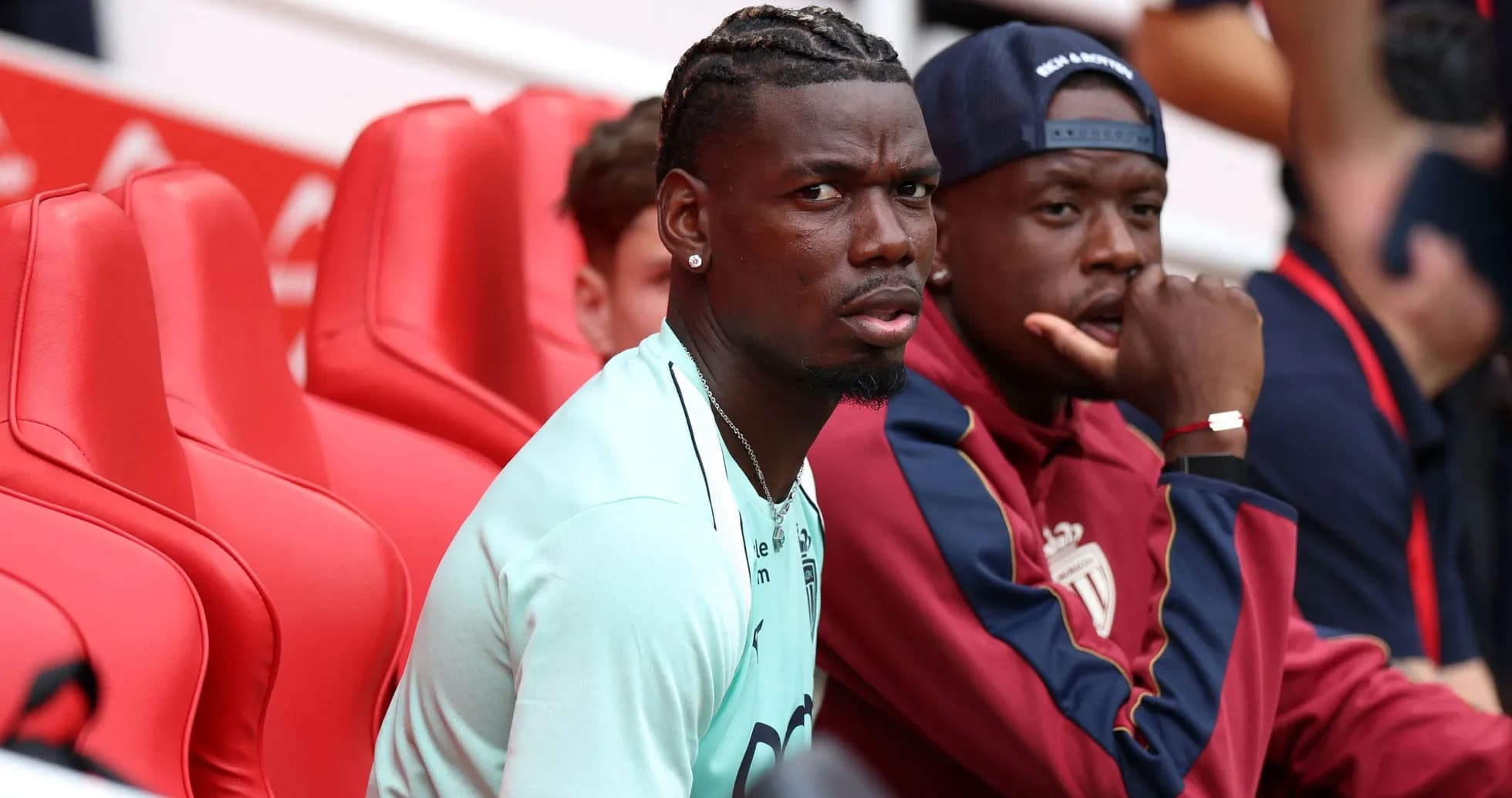Two players sitting on red bench during match