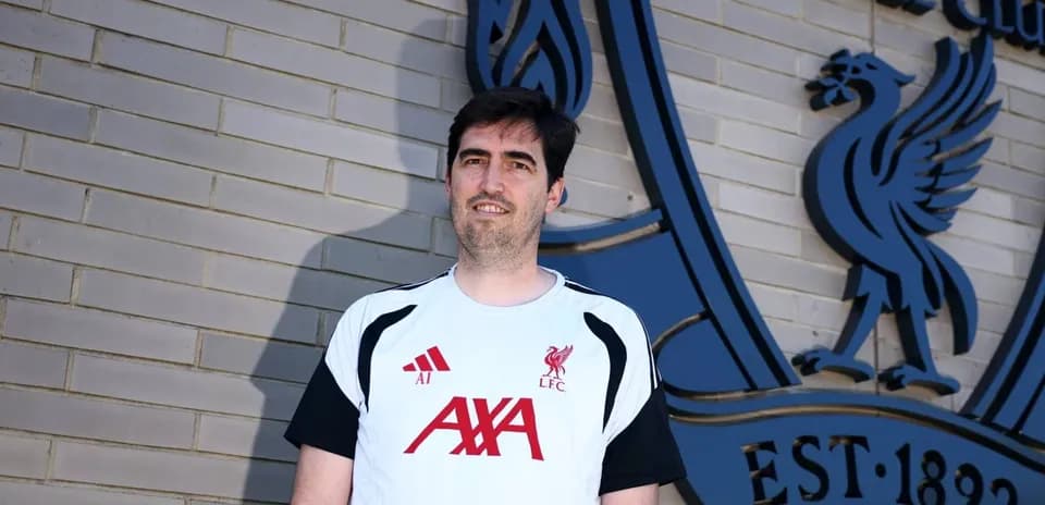 Person in Liverpool FC training kit by club logo