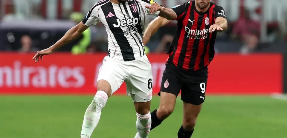 Juventus player challenges AC Milan opponent for the ball