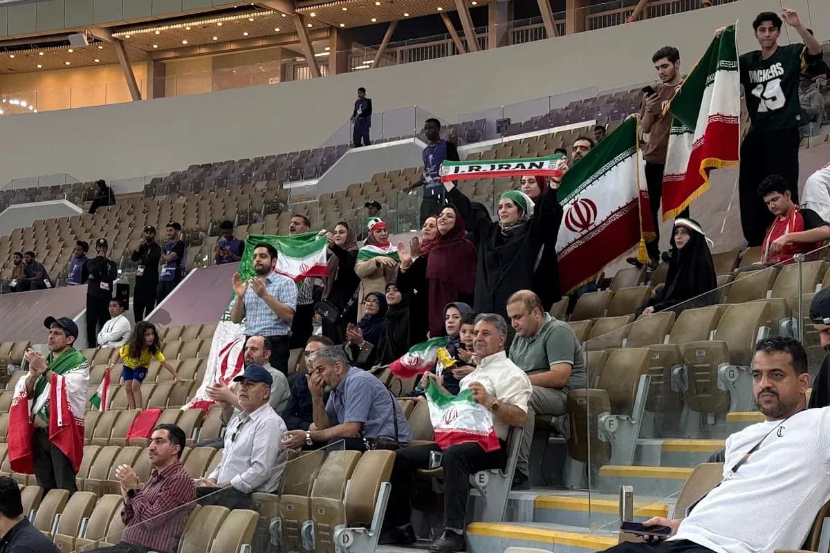 Iranian fans cheering and waving flags in stadium