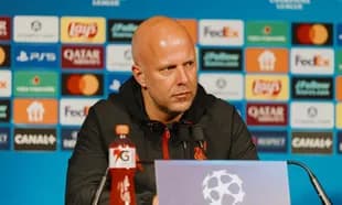 Manager speaking at press conference with sponsor backdrop