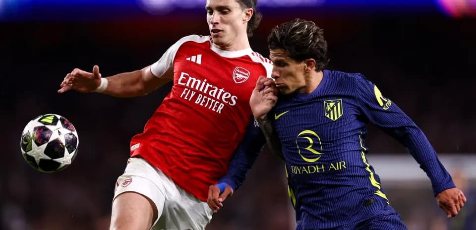 Arsenal player challenges Atletico player for the ball
