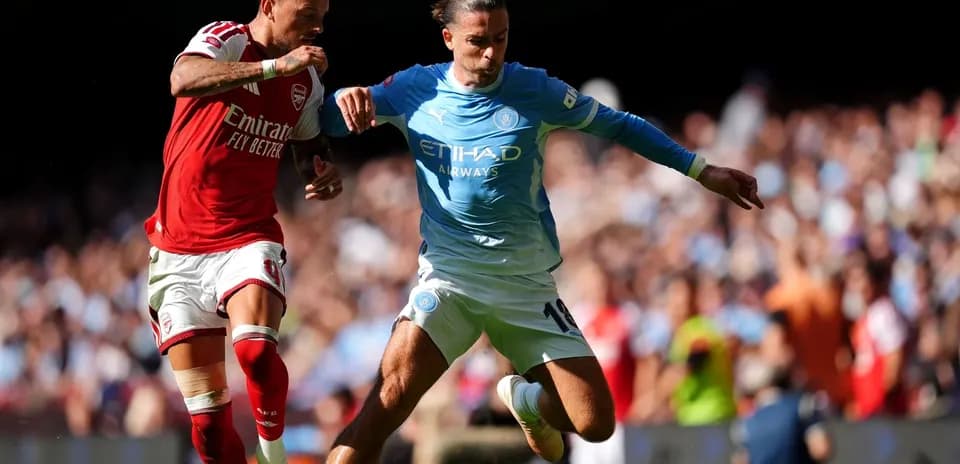 Arsenal and Manchester City players contesting for the ball