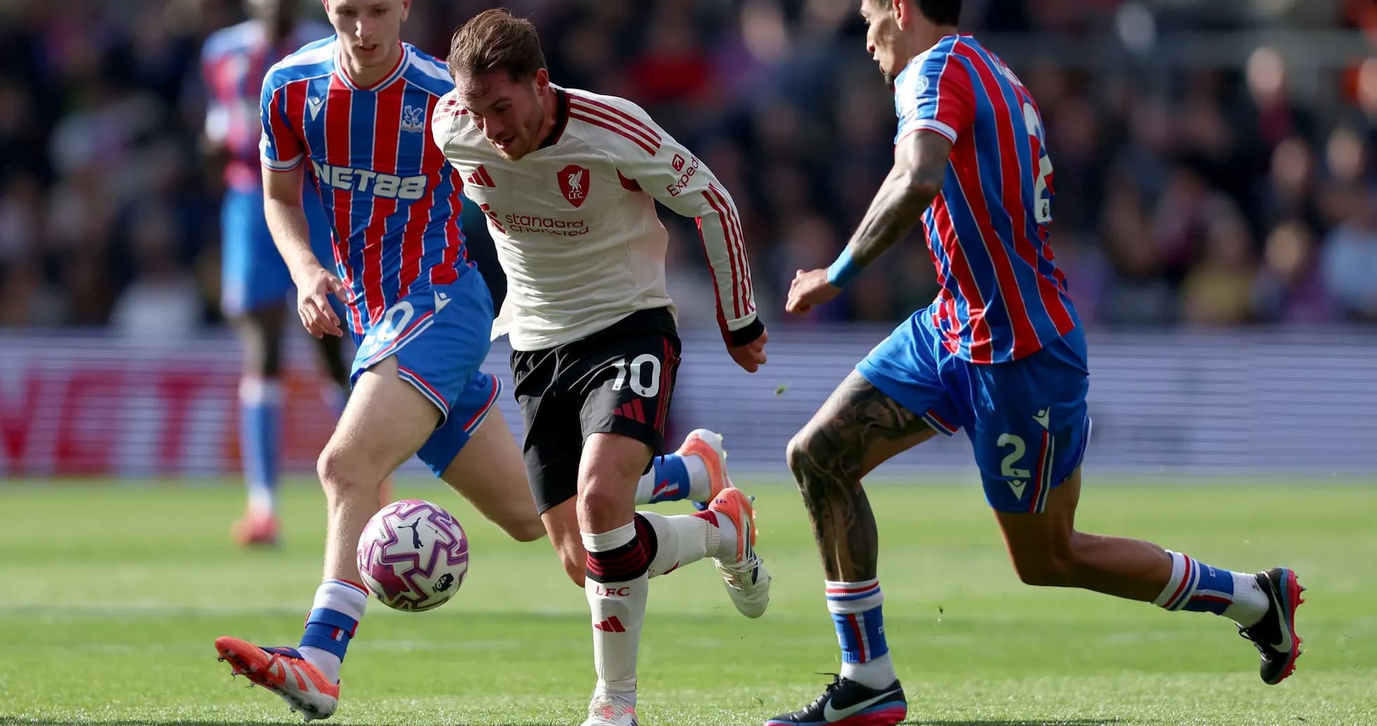Liverpool player dribbling past Crystal Palace defenders