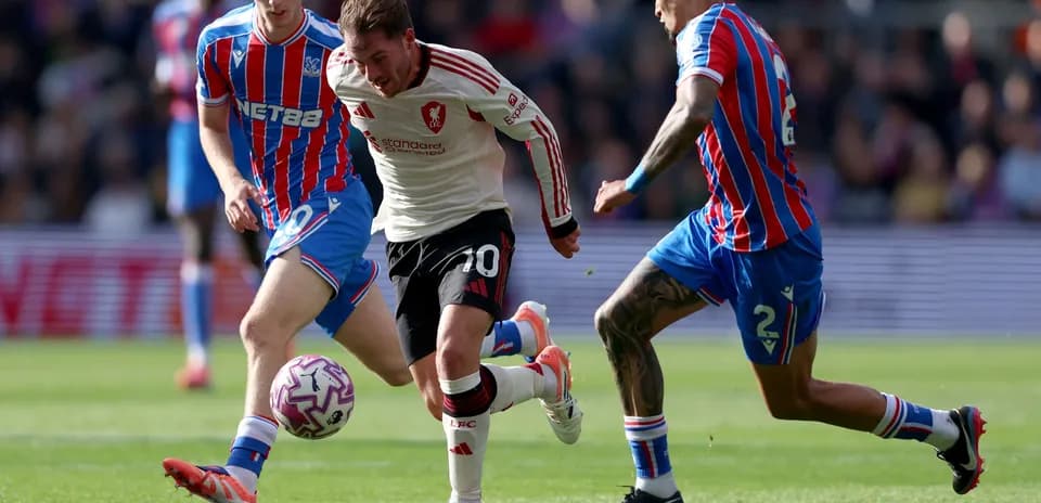 Liverpool player dribbling past Crystal Palace defenders