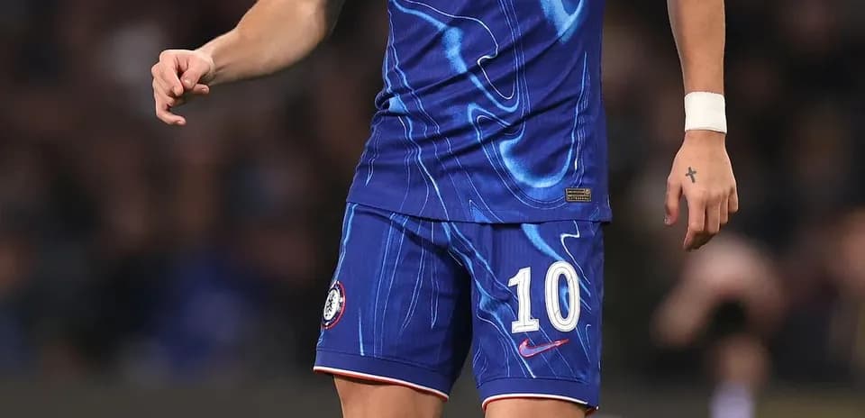 Player in blue Chelsea kit with ball on pitch