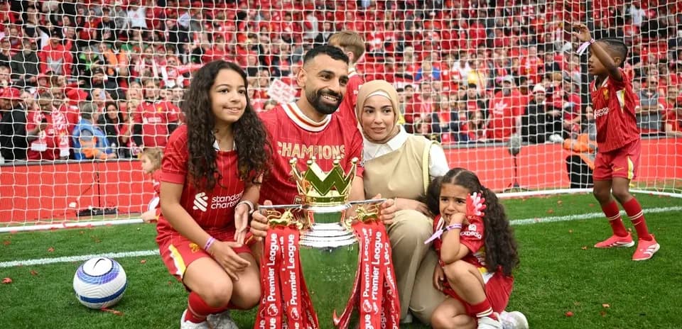 Player celebrating Premier League title with family and trophy