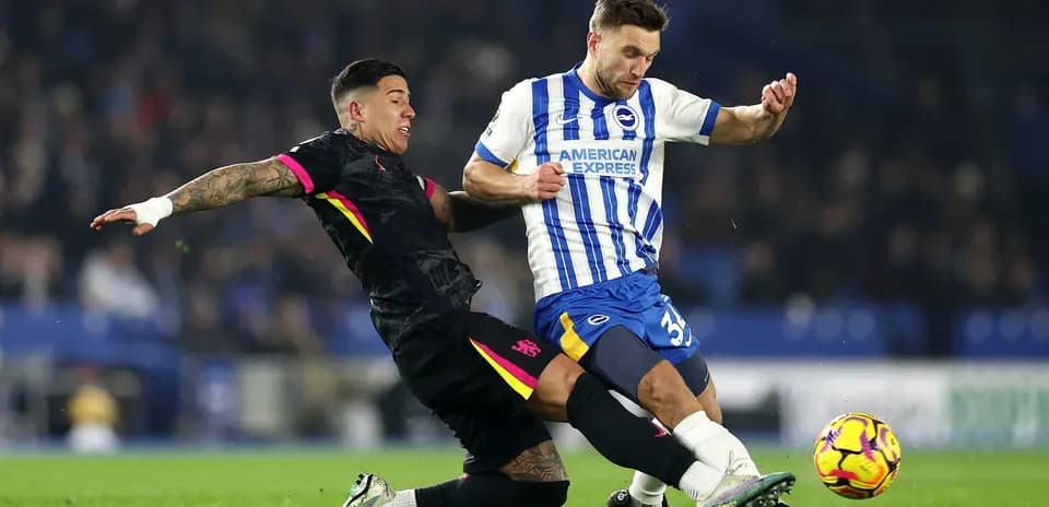Brighton player tackling Chelsea opponent during match