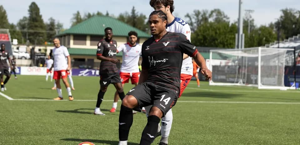 Player in black jersey preparing to pass ball