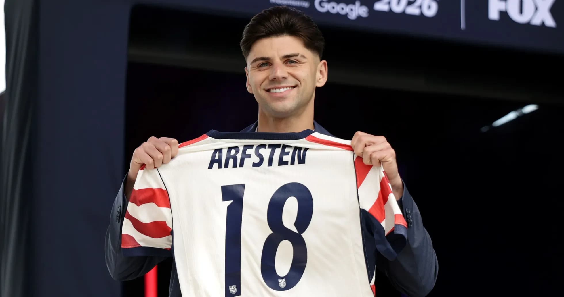 Player holding jersey with name Arfsten and number 18