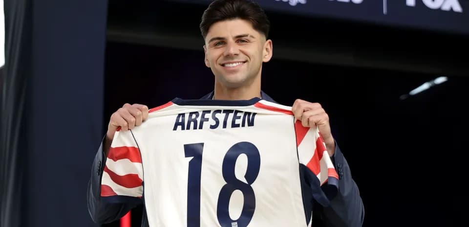Player holding jersey with name Arfsten and number 18