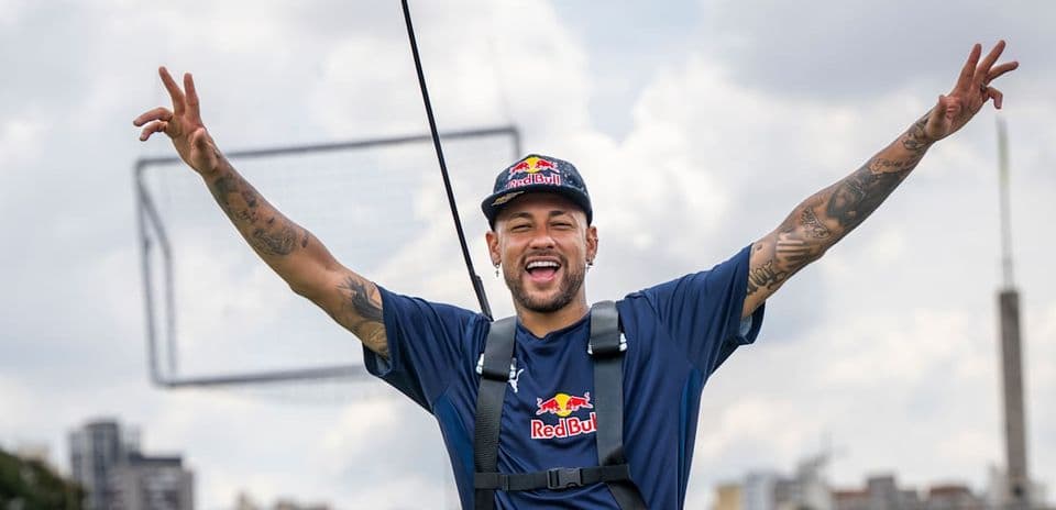 Neymar celebrating with arms raised in outdoor setting