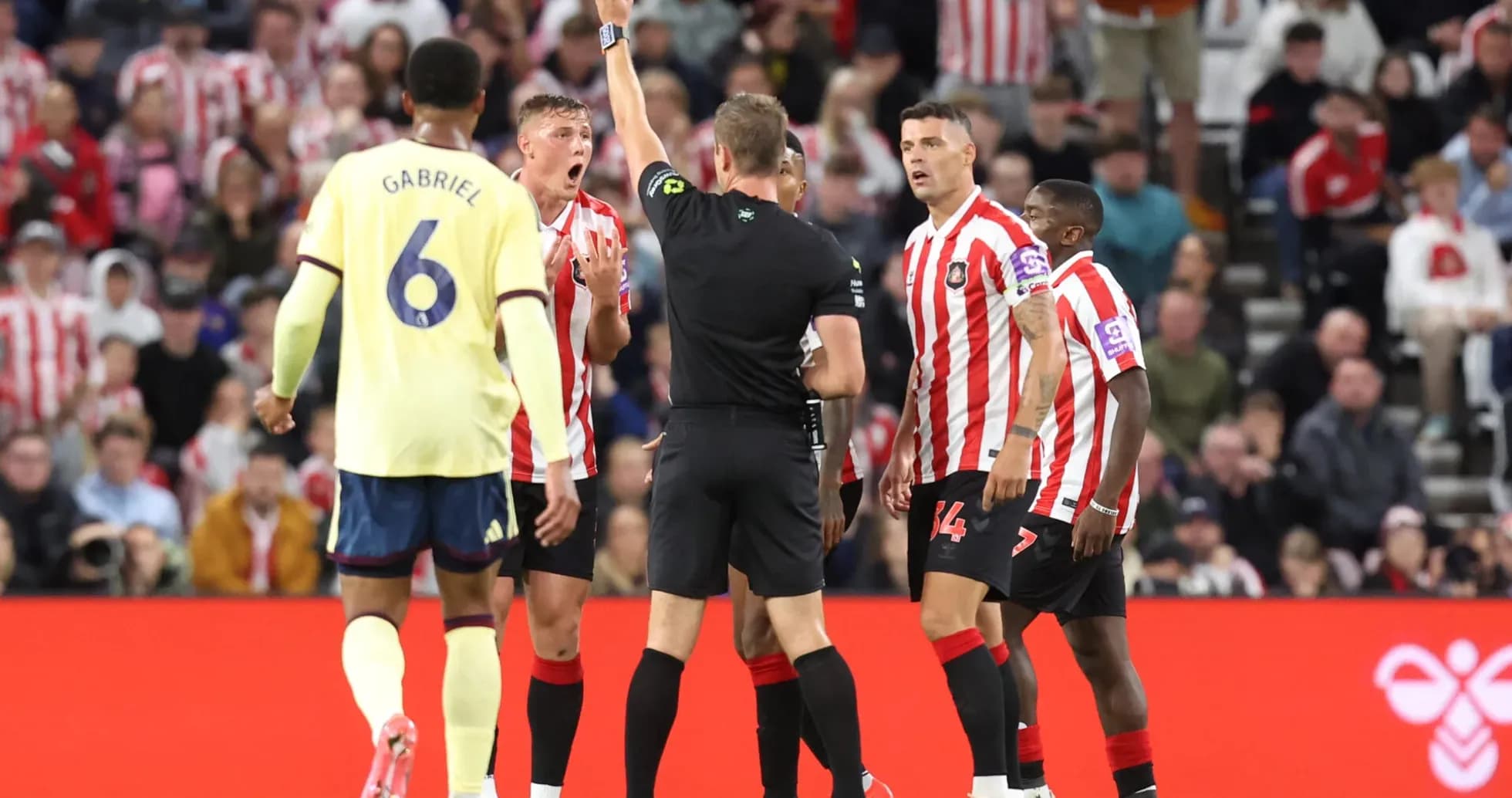 Referee showing yellow card during Sunderland vs Arsenal match