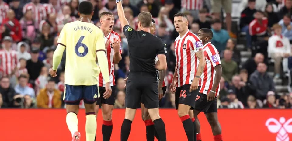 Referee showing yellow card during Sunderland vs Arsenal match