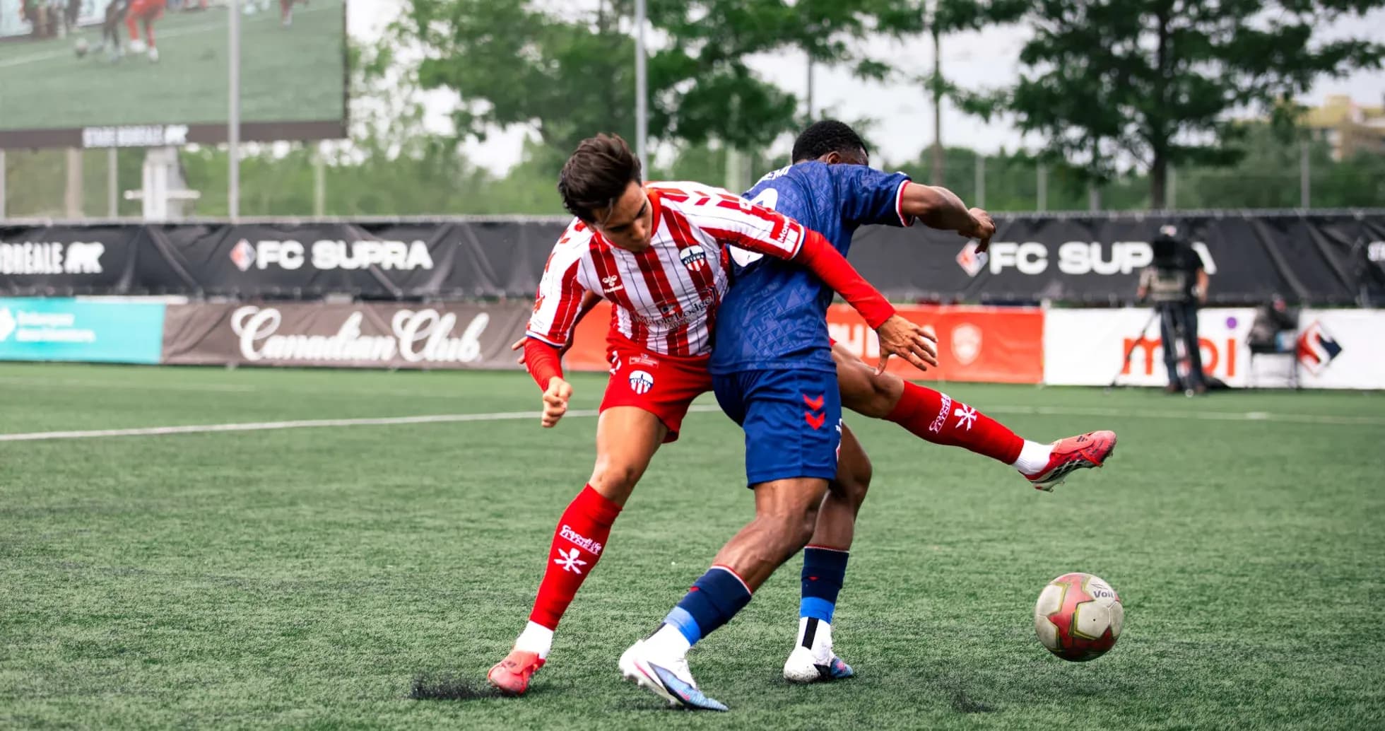 Two players competing for the ball in football match