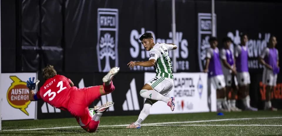 Player attempting to score against goalkeeper in match
