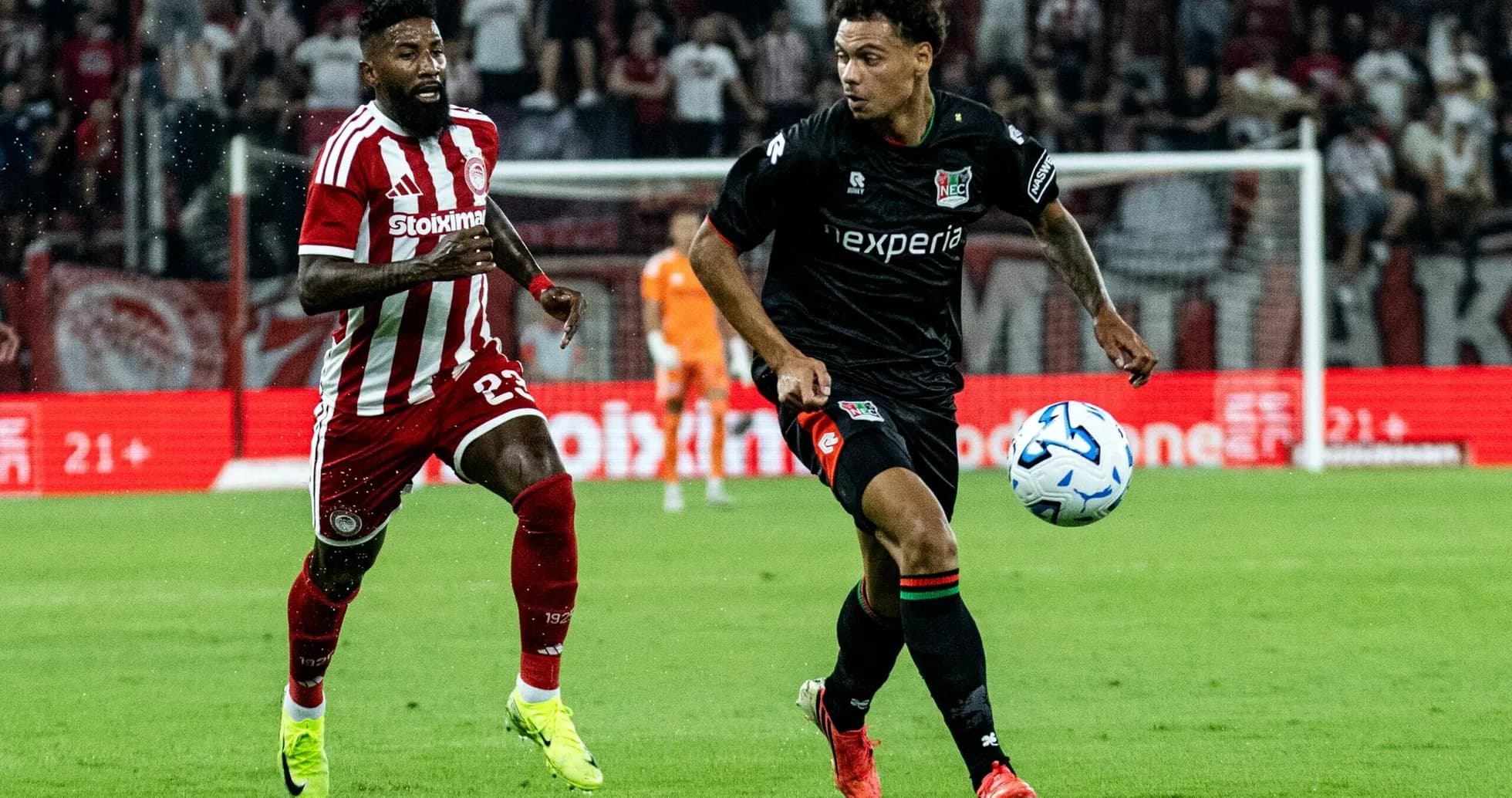 NEC player dribbling against Olympiakos defender