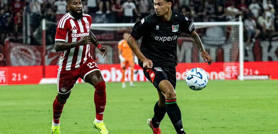 NEC player dribbling against Olympiakos defender