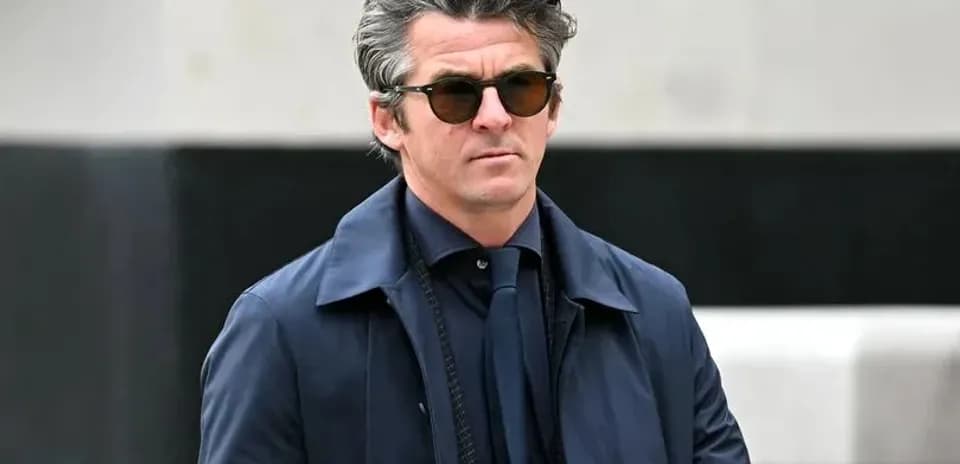 Man in sunglasses wearing a navy coat outdoors