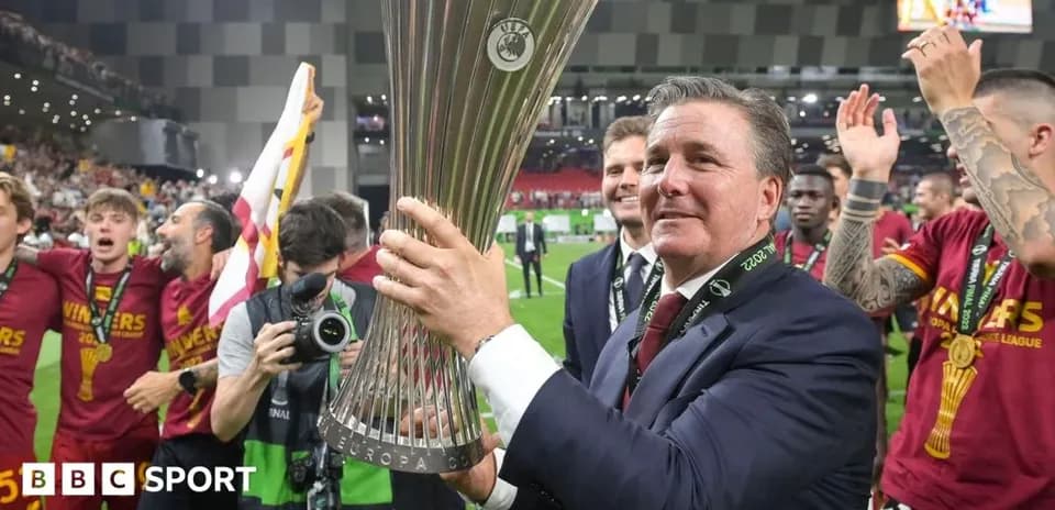 Coach holding UEFA Europa League trophy with celebrating team
