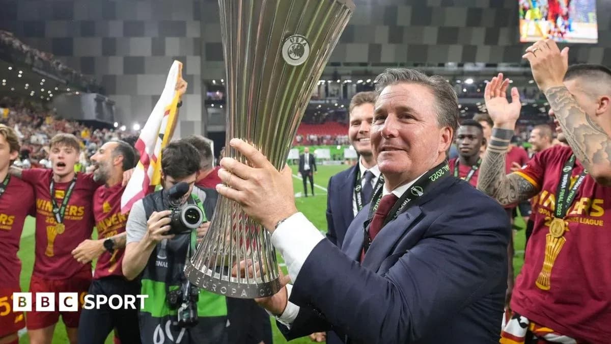 Coach holding UEFA Europa League trophy with celebrating team